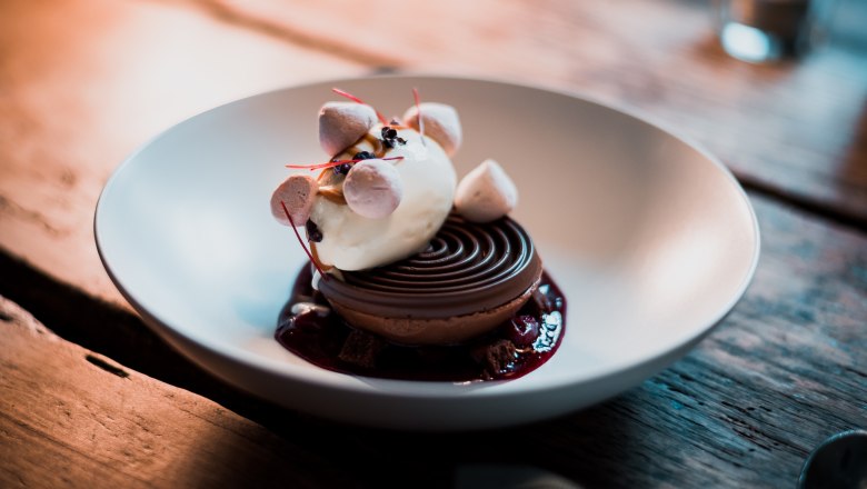 Čokoládová kupola - mousse / brownie / zmrzlina / crumble, © Vinzenz Pauli/Philip Hinteregger Dezert so zmrzlinou, penou a drobenkou podávaný v miske.