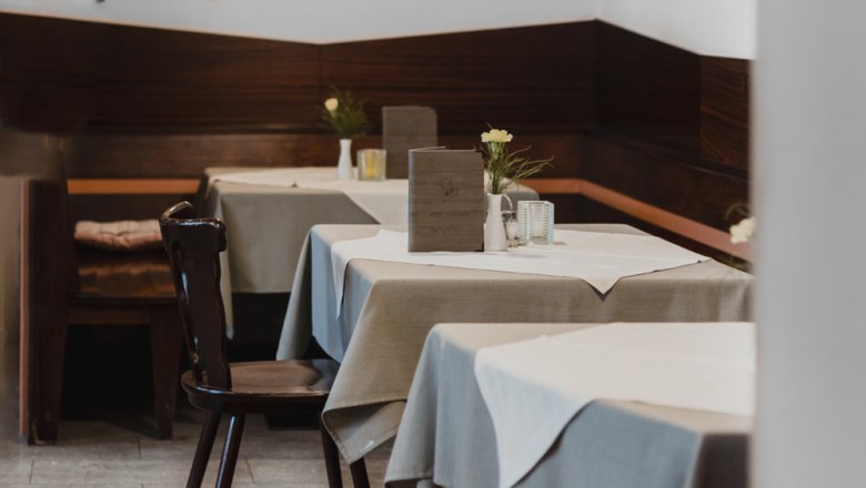 Smrekový salón alebo zelená záhrada na nádvorí, © Niederösterreich Werbung/David Schreiber Pohľad do interiéru útulnej reštaurácie s dreveným nábytkom a prestretými stolmi.