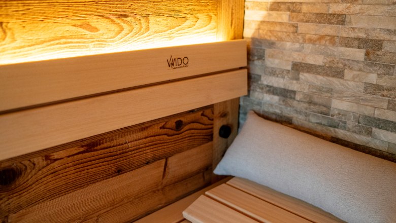 Chaty a miesta plné ZÁZRAKOV - Weidehaus De Luxe, © WUNDERVOLL eben Pohľad do interiéru sauny s dreveným obložením a kamennou stenou.