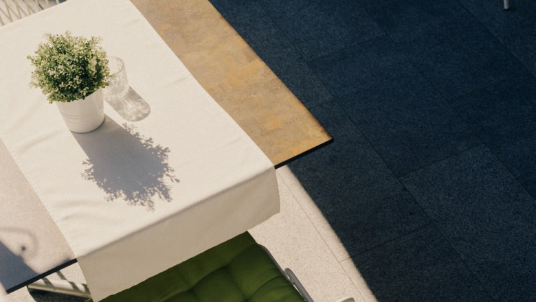 Záhrada pre hostí sa stretáva s bylinkovou záhradou, © Niederösterreich Werbung/Julius Hirtzberger Stôl s bielym obrusom, kvetináčom a sklom vonku.