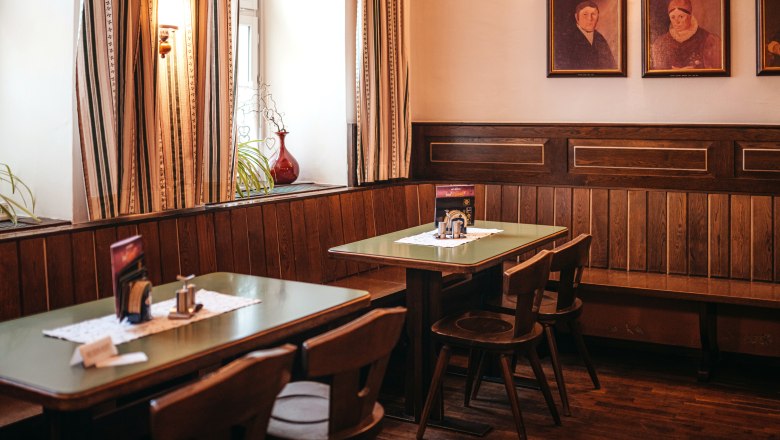 Tradičný salón na námestí Dreifaltigkeitsplatz v Zwettli, © Niederösterreich Werbung/Daniela Führer Tradičná spoločenská miestnosť s dreveným nábytkom a obrazmi na stene.