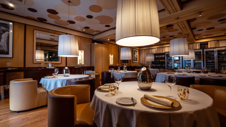 Relais & Chateaux MÖRWALD Hotel am Wagram, © Niederösterreich Werbung / Maximilian Pawlikowsky Elegantná reštaurácia s okrúhlymi stolmi, bielymi obrusmi a veľkými závesnými lampami.