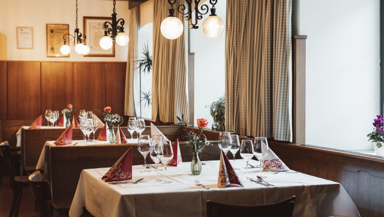 Občerstvenie v Krumbachu, © Niederösterreich Werbung/David Schreiber Útulná reštaurácia s prestretými stolmi, pohármi na víno a vázami na kvety.