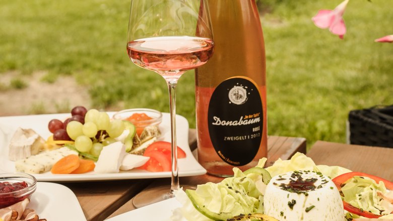 Občerstvenie v reštaurácii Strawanzer, © Rita Newman Vonkajší stôl s vínom, šalátom a syrovým tanierom vo vinárni Strawanzer