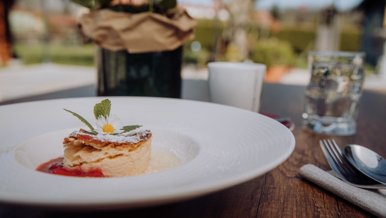 Nejde však len o ryby. Dôkaz: Štrúdľa s mliečnym krémom, © Niederösterreich Werbung/thecreatingclick.com Na drevenom stole vonku je tanier mliečnej štrúdle ozdobený sedmokráskou.