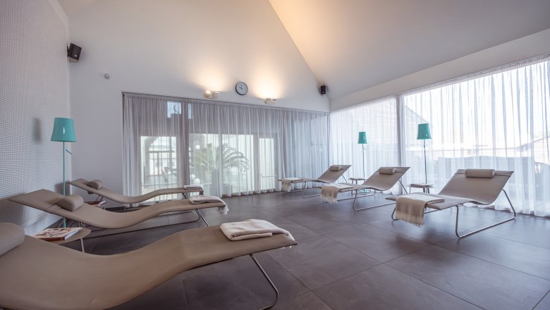 MÖRWALD, Relais Chateaux Hotel am Wagram, © Niederösterreich Werbung / Maximilian Pawlikowsky Svetlá relaxačná miestnosť s lehátkami a závesmi.
