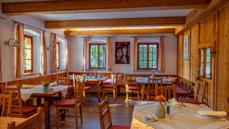 Posteľ vo Wies'n, © Niederösterreich Werbung / Maximilian Pawlikowsky Útulná jedáleň s dreveným nábytkom a prestretými stolmi.