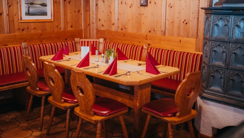 Útulný salónik, © Niederösterreich Werbung/Daniela Führer Útulný salónik s dreveným nábytkom, červeným čalúnením a kachľovou pecou.