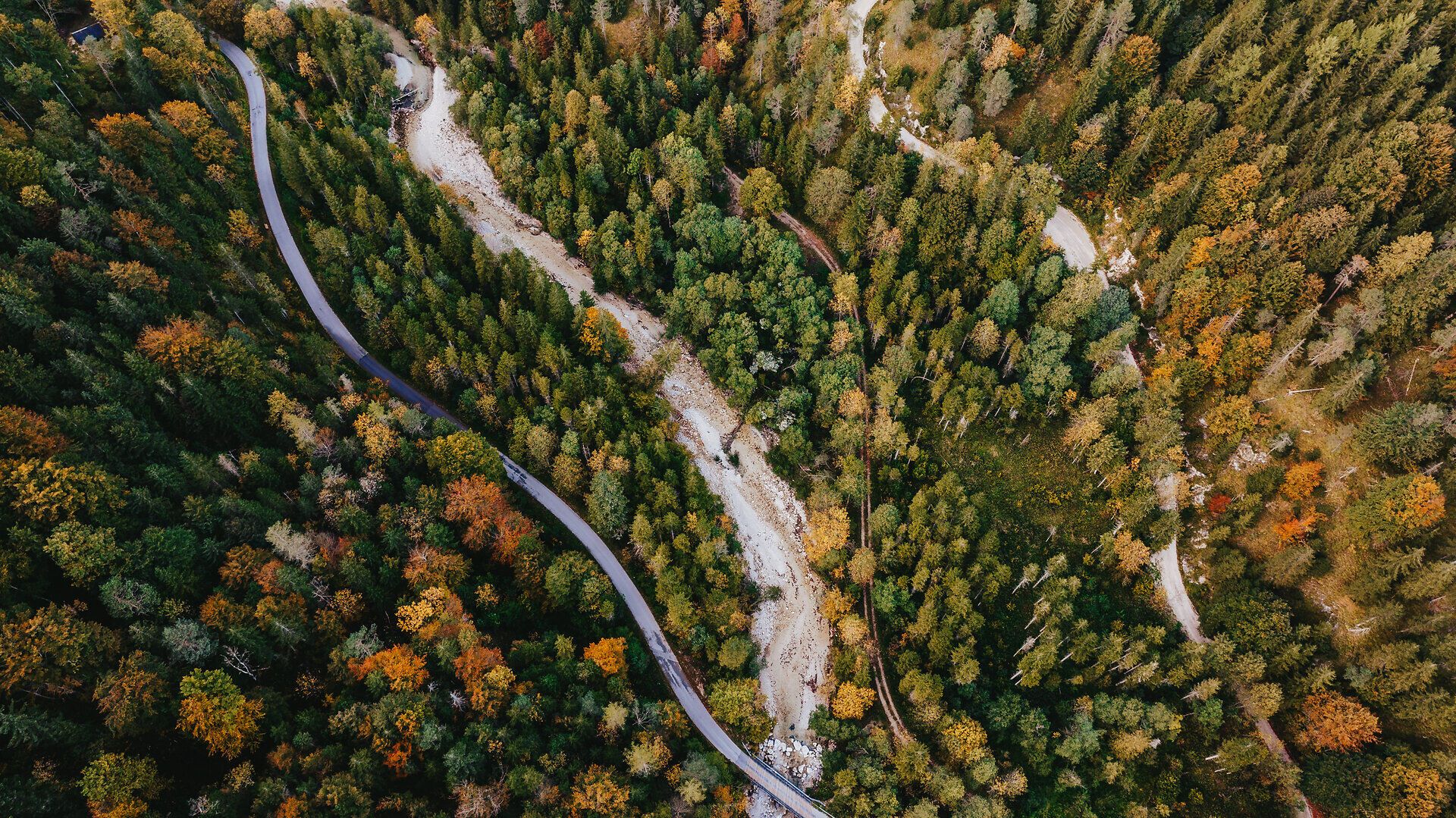 Die bunten Blätter der Bäume leuchten im warmen Licht des Herbstes und laden zu einem entspannenden Spaziergang ein. Der sanfte Fluss schlängelt sich durch die malerische Landschaft, während die majestätischen Berge im Hintergrund eine beeindruckende Kulisse bieten. Hier, in der unberührten Natur, findet jeder Besucher Ruhe und Inspiration.