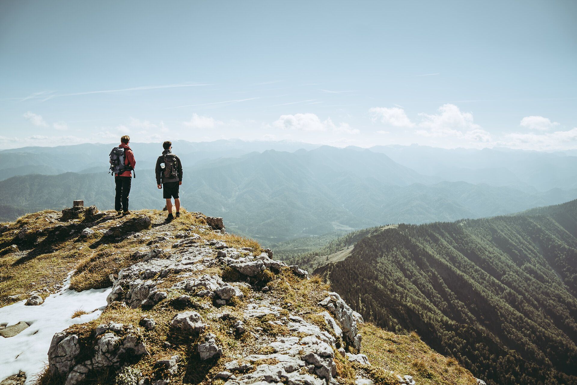 Dvaja turisti stoja na vrchole a vychutnávajú si úchvatný výhľad na Ybbstalské Alpy. Svieži horský vzduch a majestátna krajina vás pozývajú na oddych a spoznávanie krás prírody.