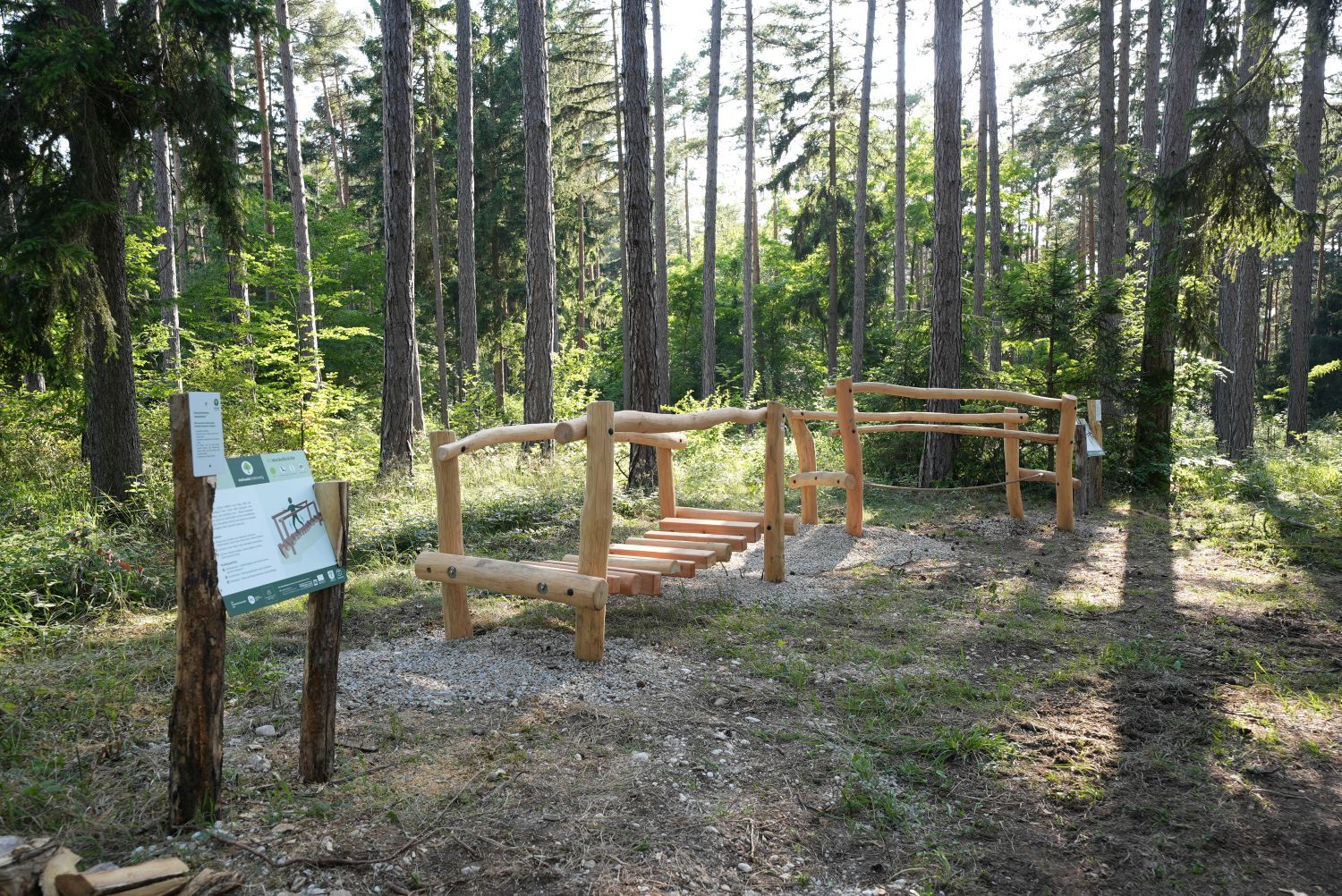 Drevené zariadenie v lese s informačnou tabuľou v liečivom lese Göttweig.