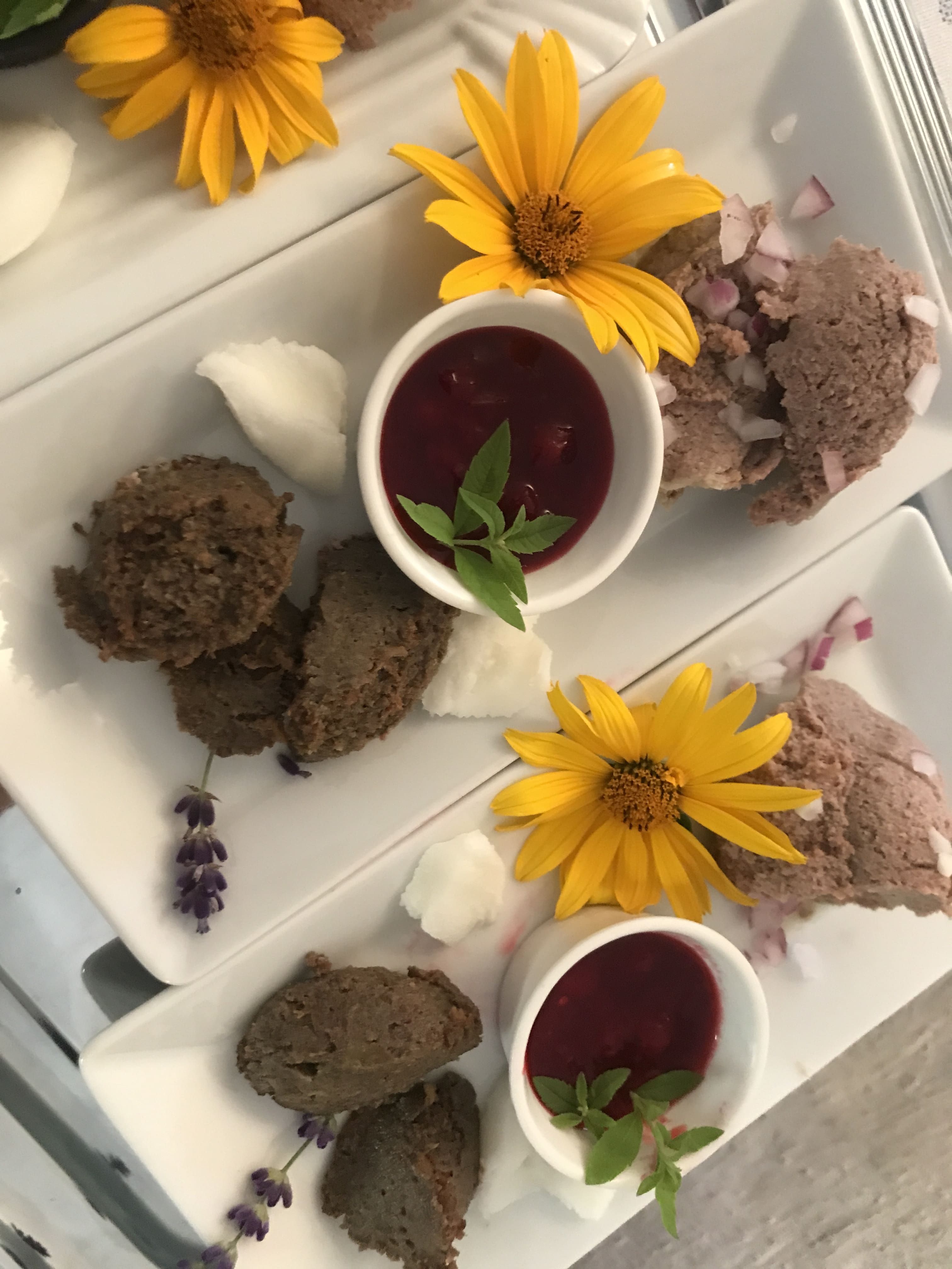 Taniere s nátierkami, žlté kvety a červené omáčky v malých miskách.