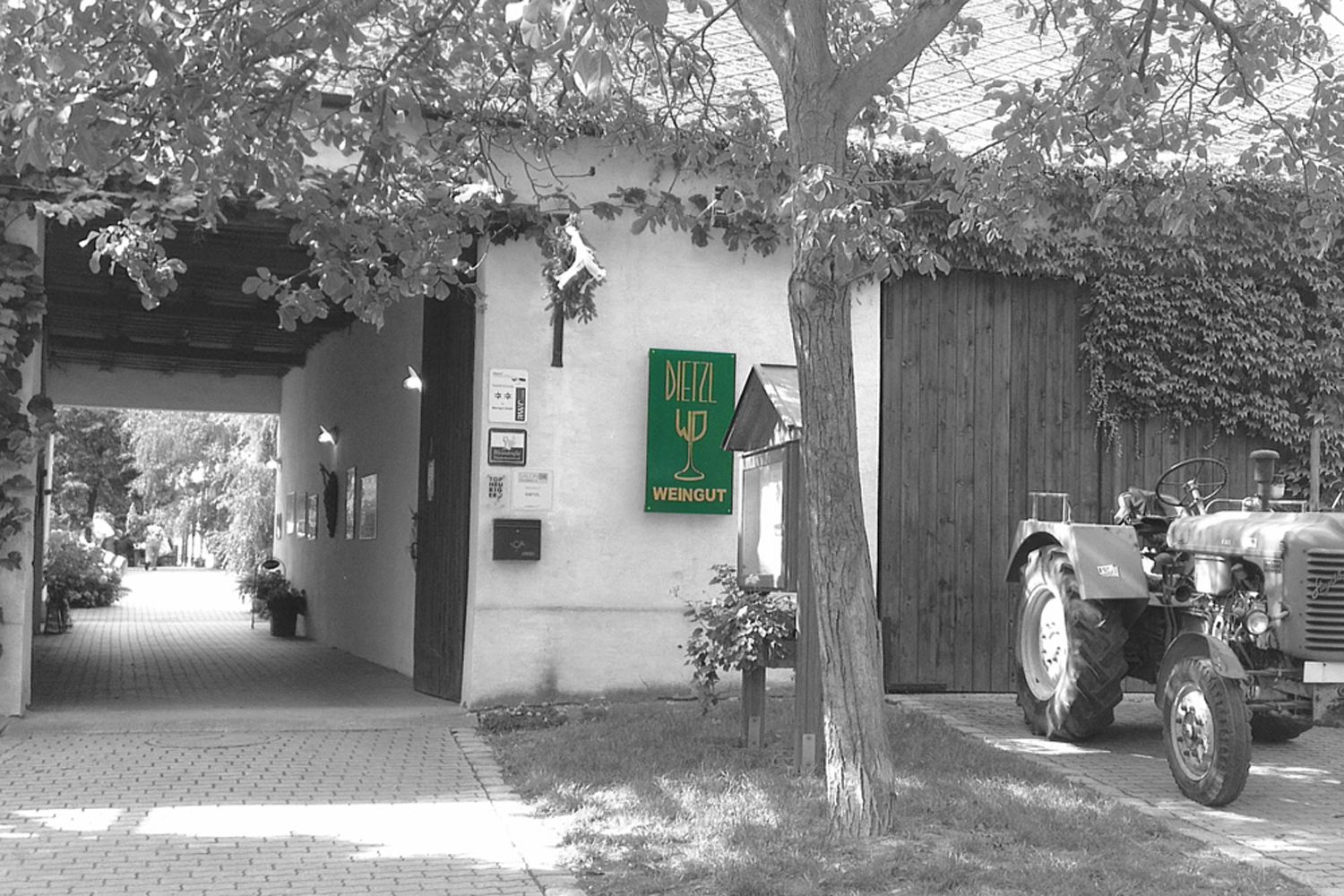 Vchod do vinárstva s nápisom "Dietzl Weingut" a traktorom vedľa neho.