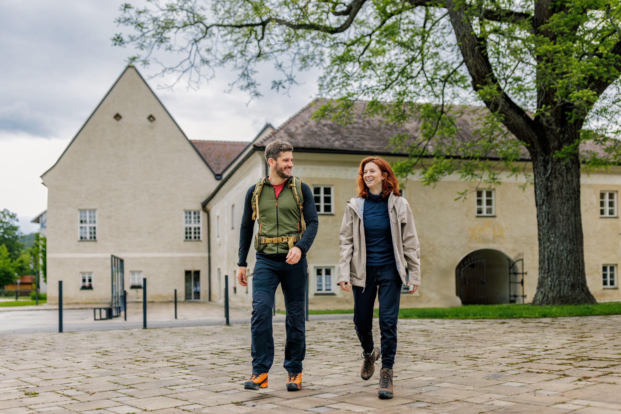 Muž a žena v turistickom oblečení pred hradom Katzelsdorf