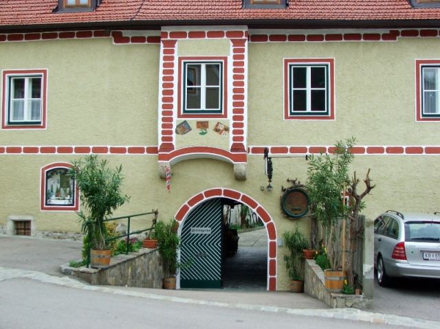 Historická budova s podlubím a červenými tehlami.