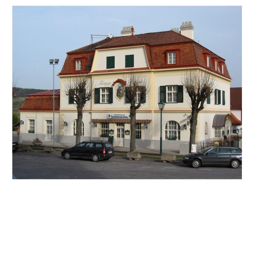 Dvojposchodová budova s červenými škridlami a zelenými okenicami, označená ako Pension Bärenschlössl.