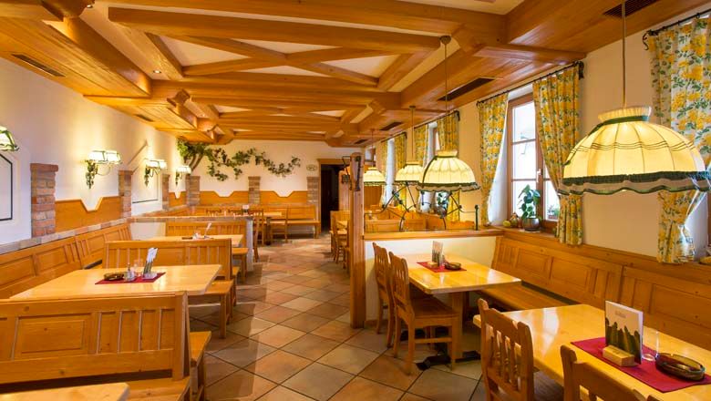 Pohľad do interiéru tradičnej vinárne s dreveným nábytkom a útulným osvetlením.