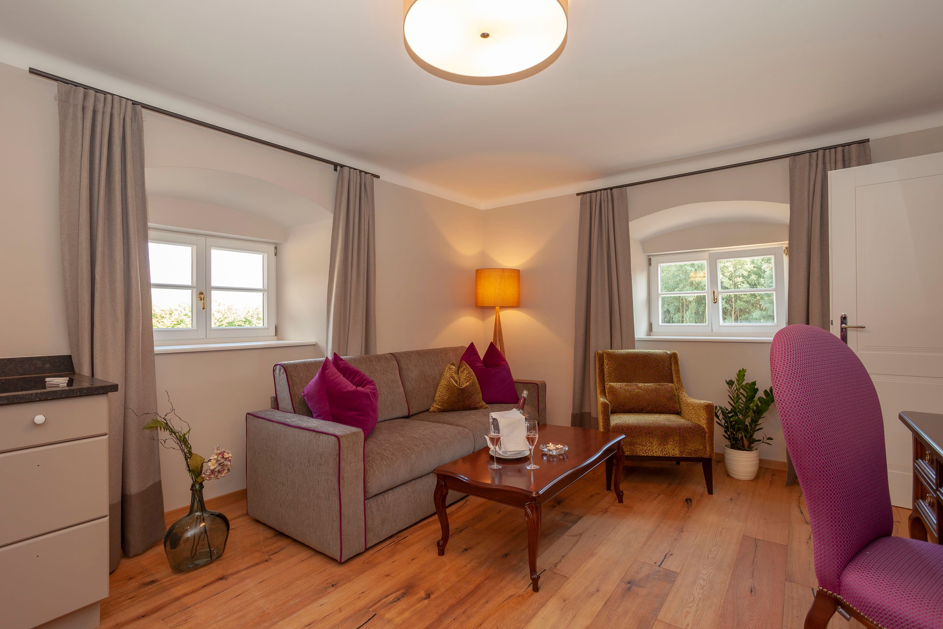 Elegantný apartmán s pohovkou, kreslom, stolom a dekoráciami.