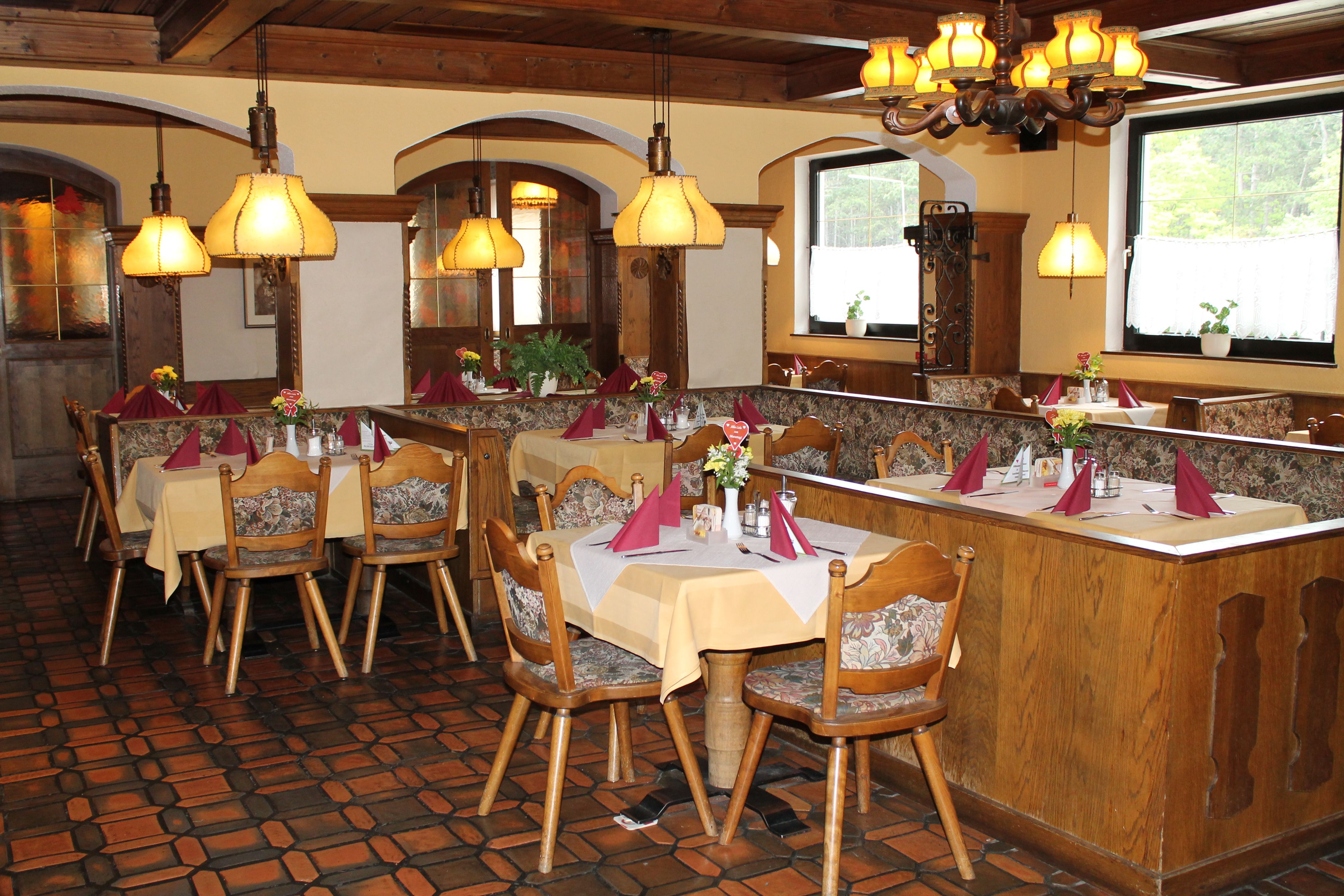 Útulná reštaurácia s dreveným nábytkom a prestretými stolmi.