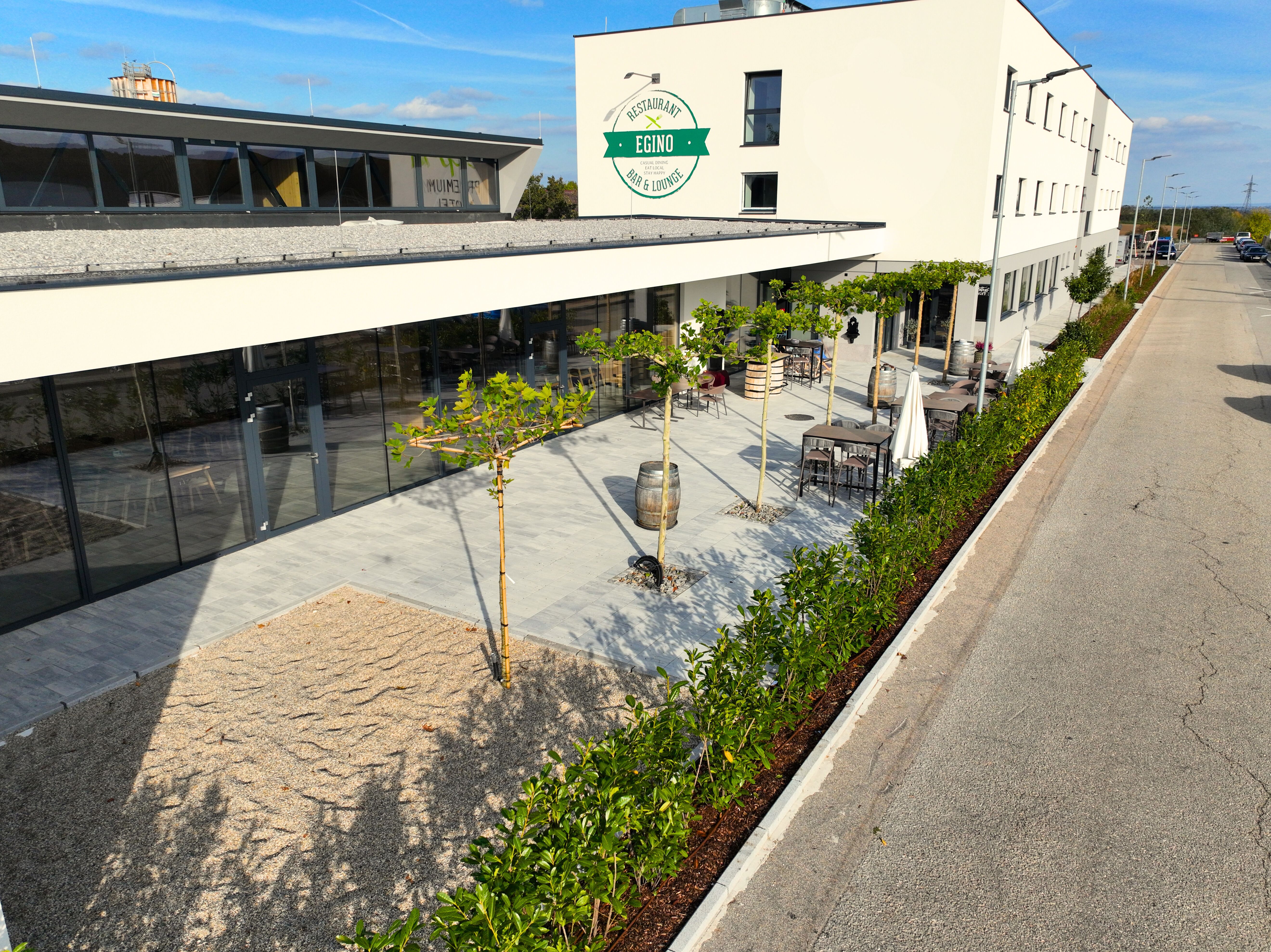 Exteriérový pohľad na modernú budovu s terasou a rastlinami.