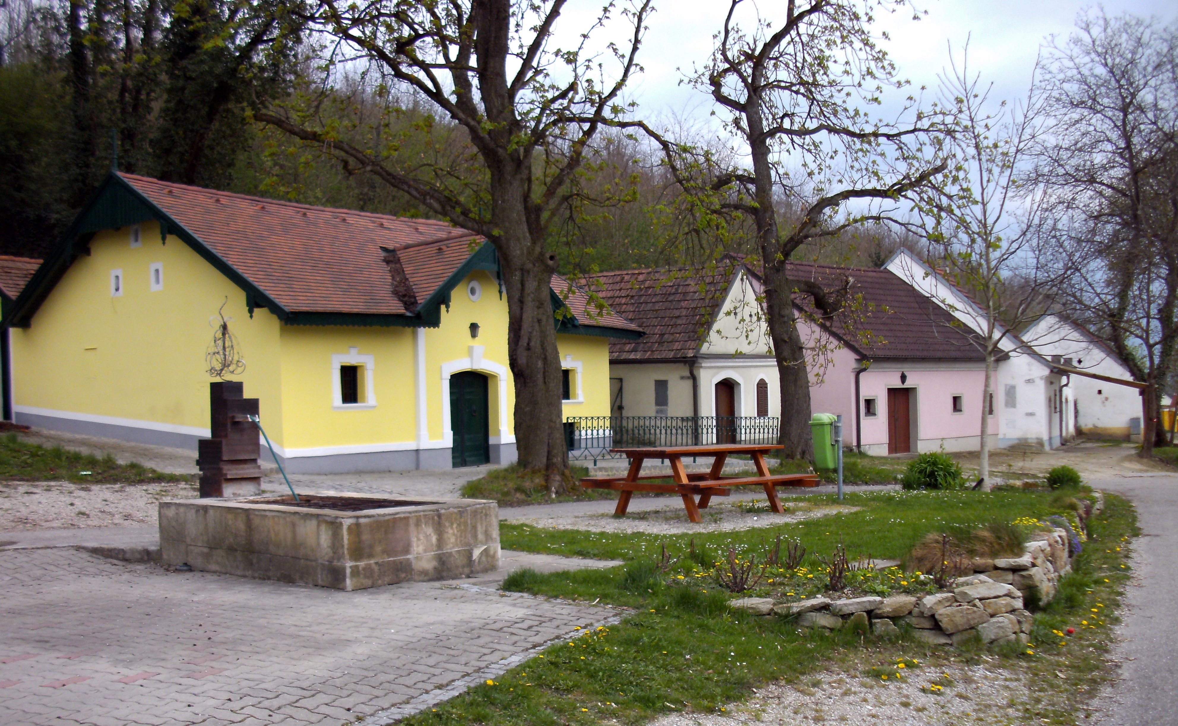 Vínna ulička v Absdorfe s farebnými domami a stromami.