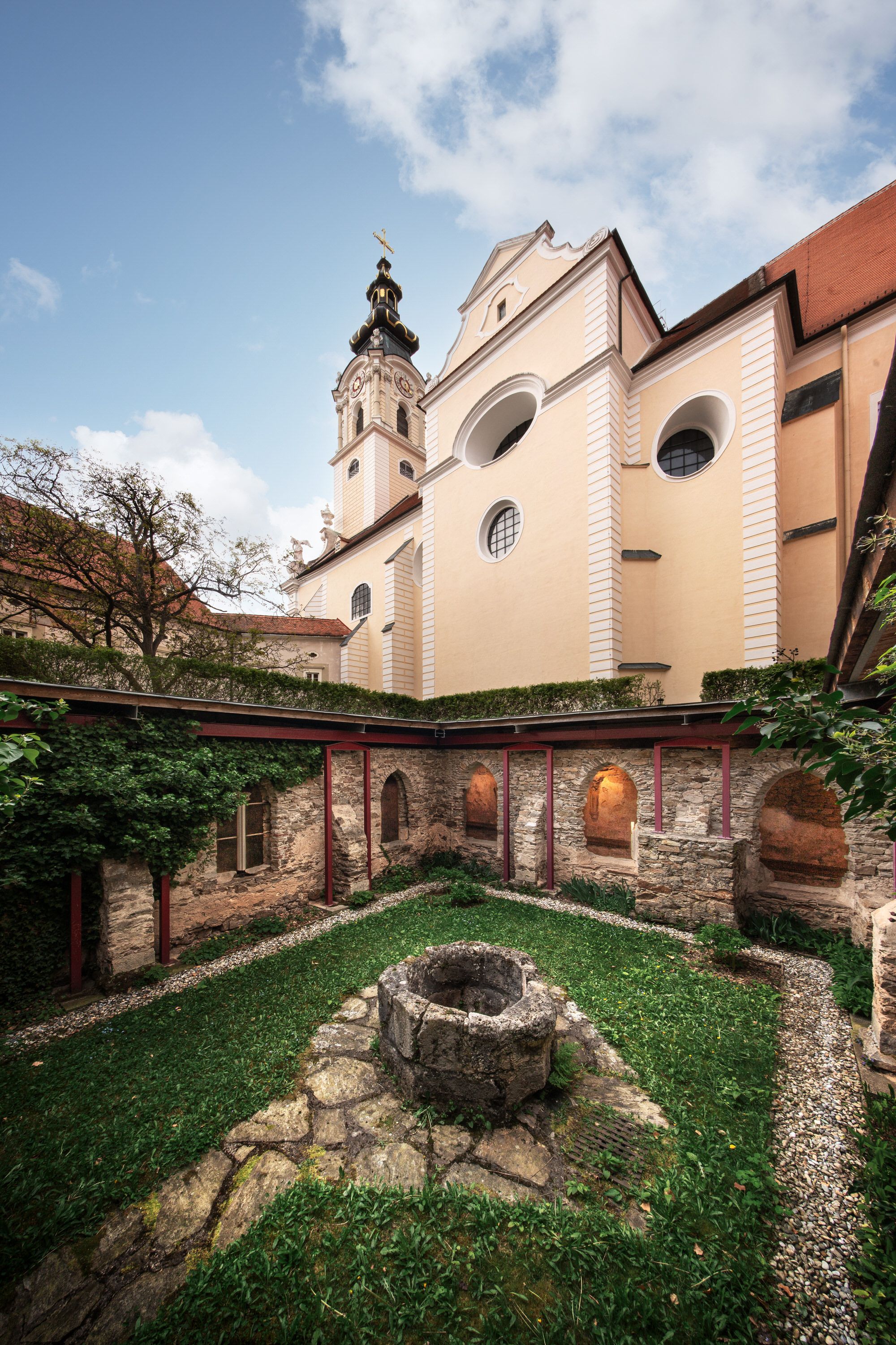 Vnútorné nádvorie opátstva Altenburg s fontánou a kostolnou vežou v pozadí.