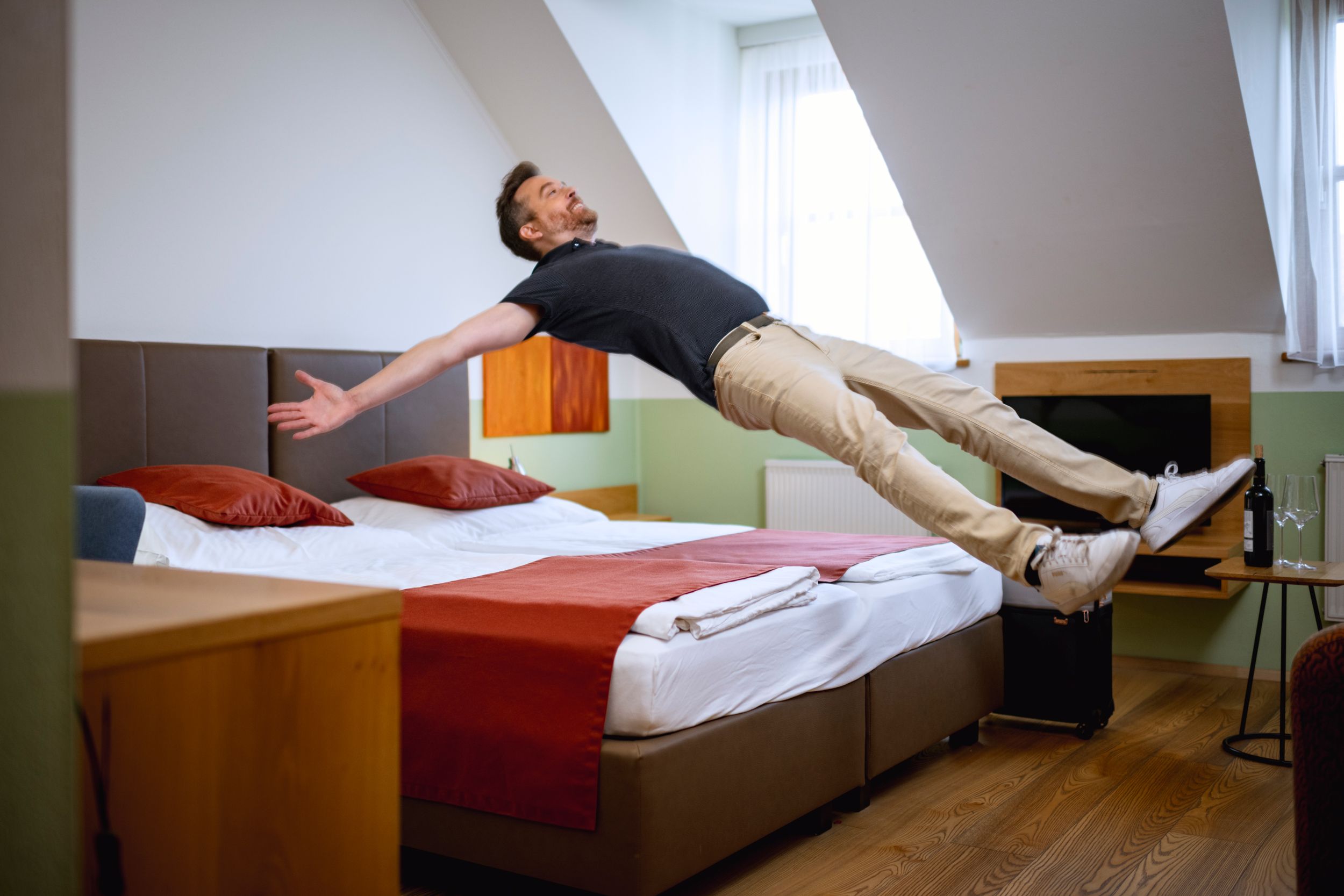 Dvojlôžková izba vinárstvo & izba pre hostí Edelmann, muž skáče na posteli