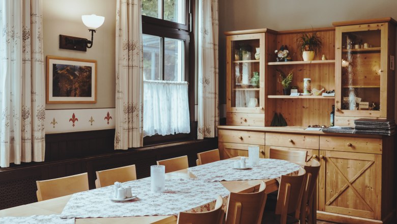 Útulná jedáleň s dreveným nábytkom a obrusmi.