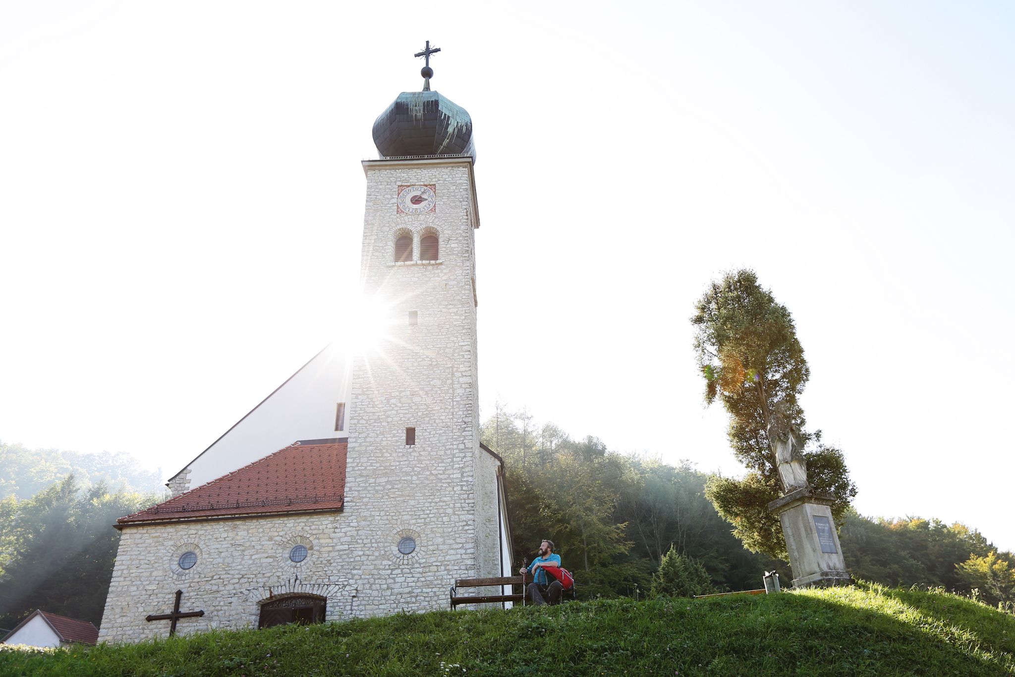 Pútnický kostol Maria Schnee so slnečnými lúčmi cez kostolnú vežu.