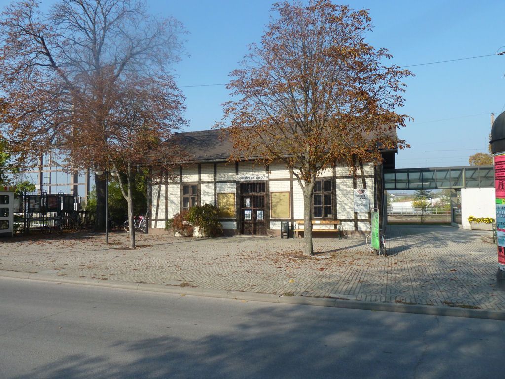 Stará budova železničného múzea Deutsch-Wagram so stromami v popredí.