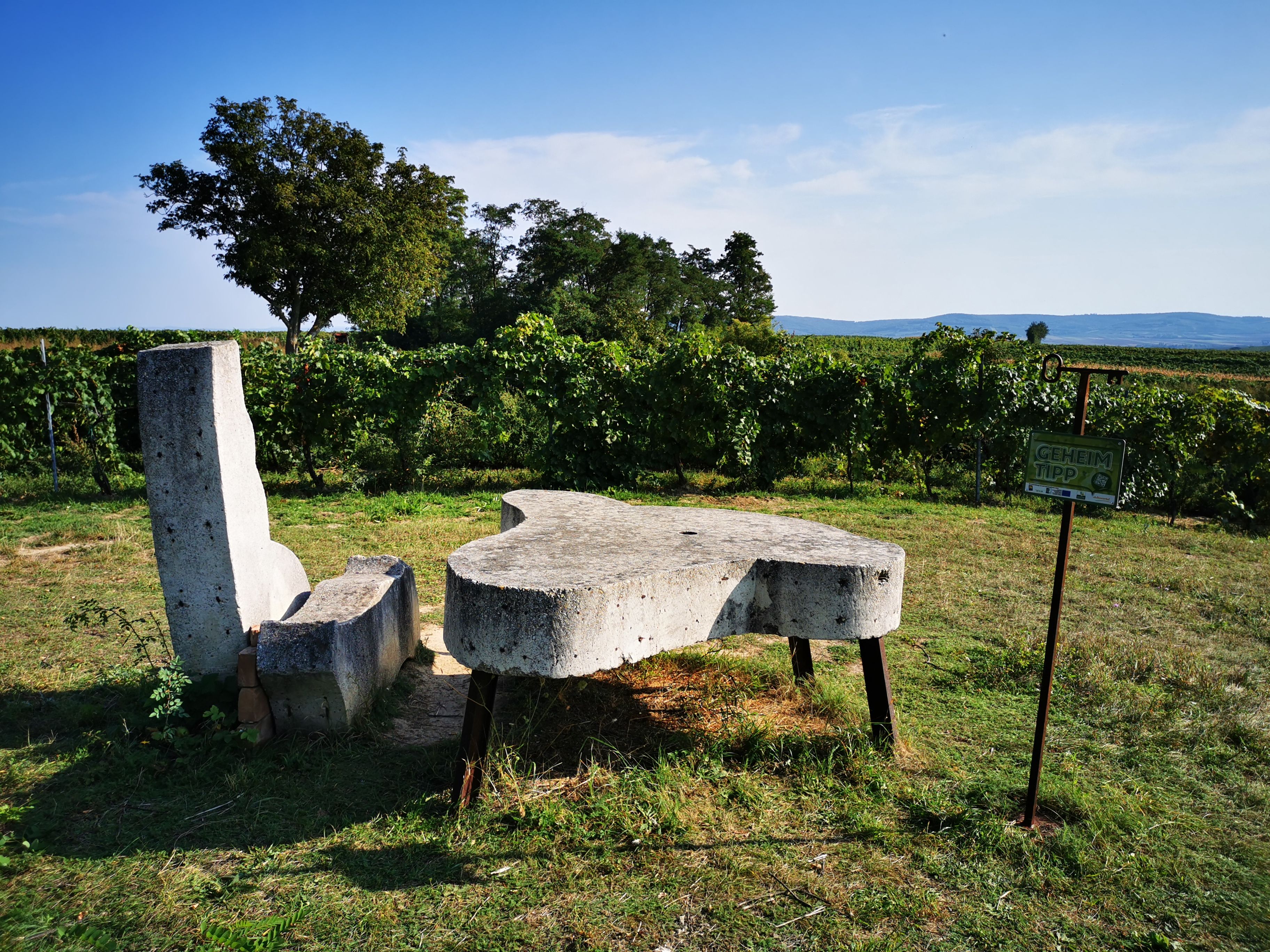 Kamenná lavička a stôl vo vinici s nápisom "insider tip".
