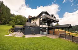 Ötscher Lodge v zelenom zalesnenom prostredí s modrou oblohou.