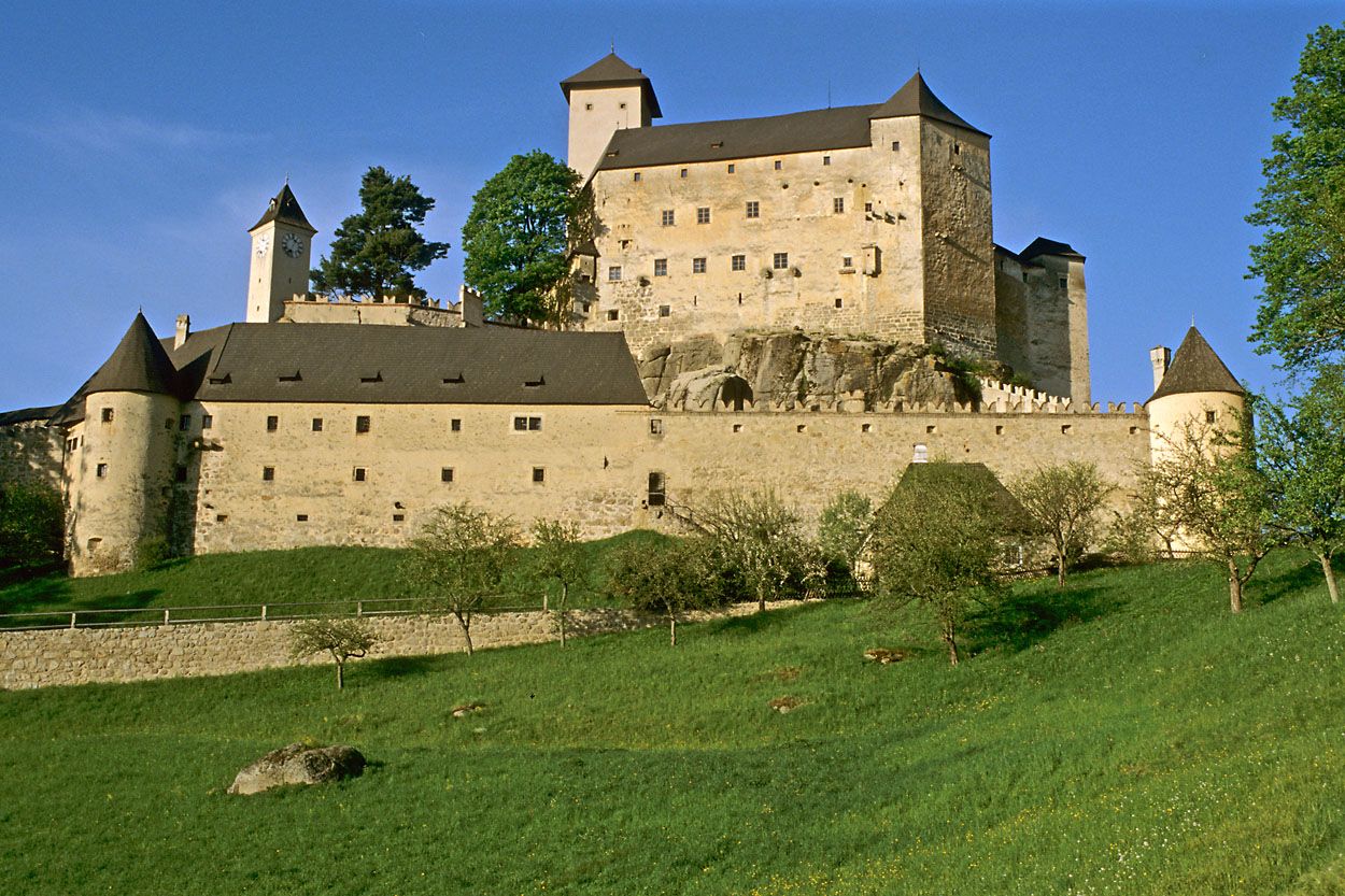 Hrad Rappottenstein na kopci so zelenou lúkou v popredí.