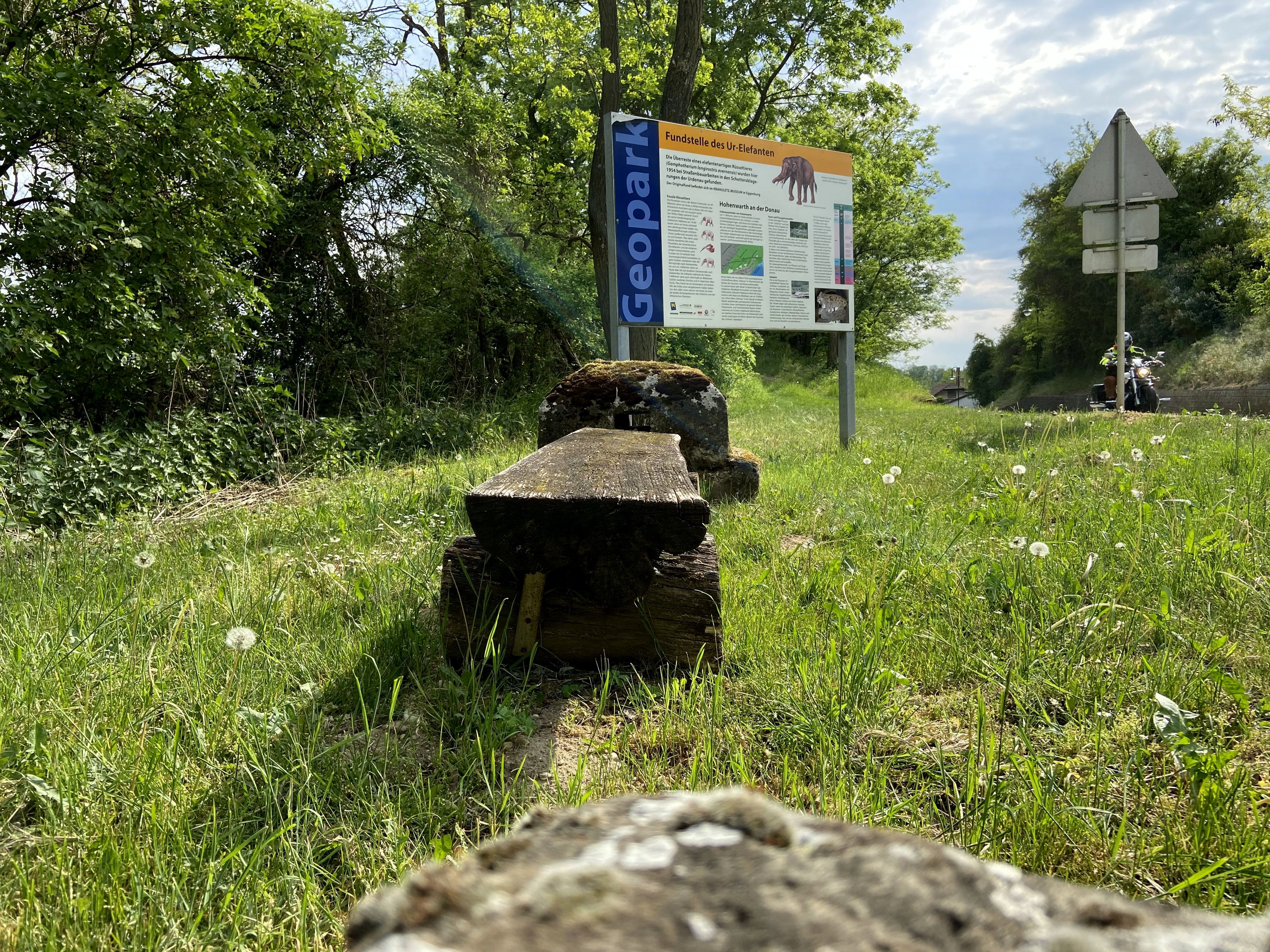Značka pre nálezisko mastodontov v Hohenwarte na lúke obklopenej stromami a cestou.