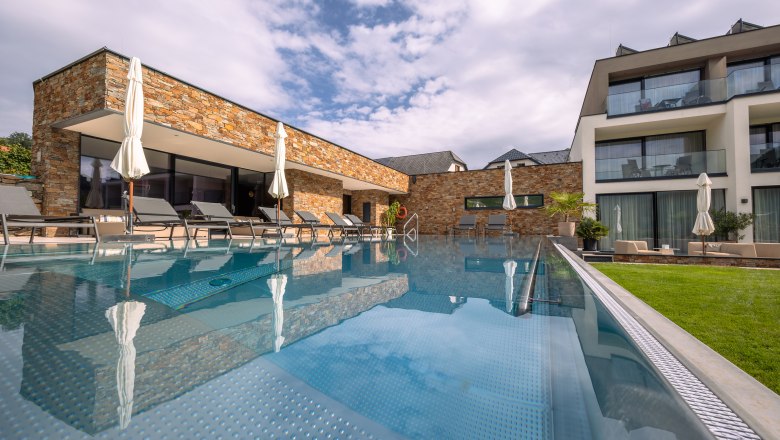 Boutique hotel WeinSpitz, © Niederösterreich Werbung / Maximilian Pawlikowsky Exteriérový pohľad na moderný hotel s bazénom a ležadlami.