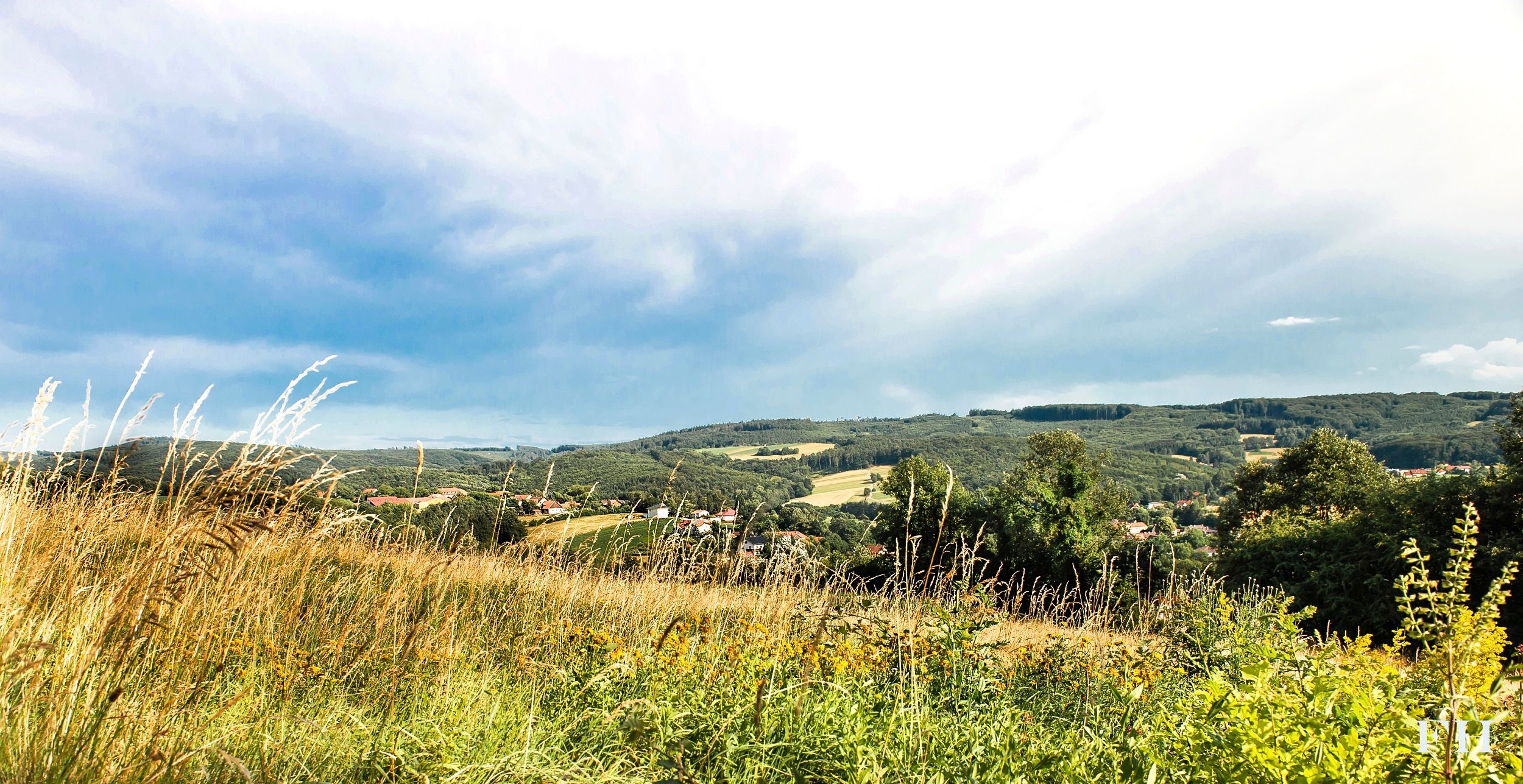 Krajina s lúkami, kopcami a zamračenou oblohou v Sieghartskirchene.