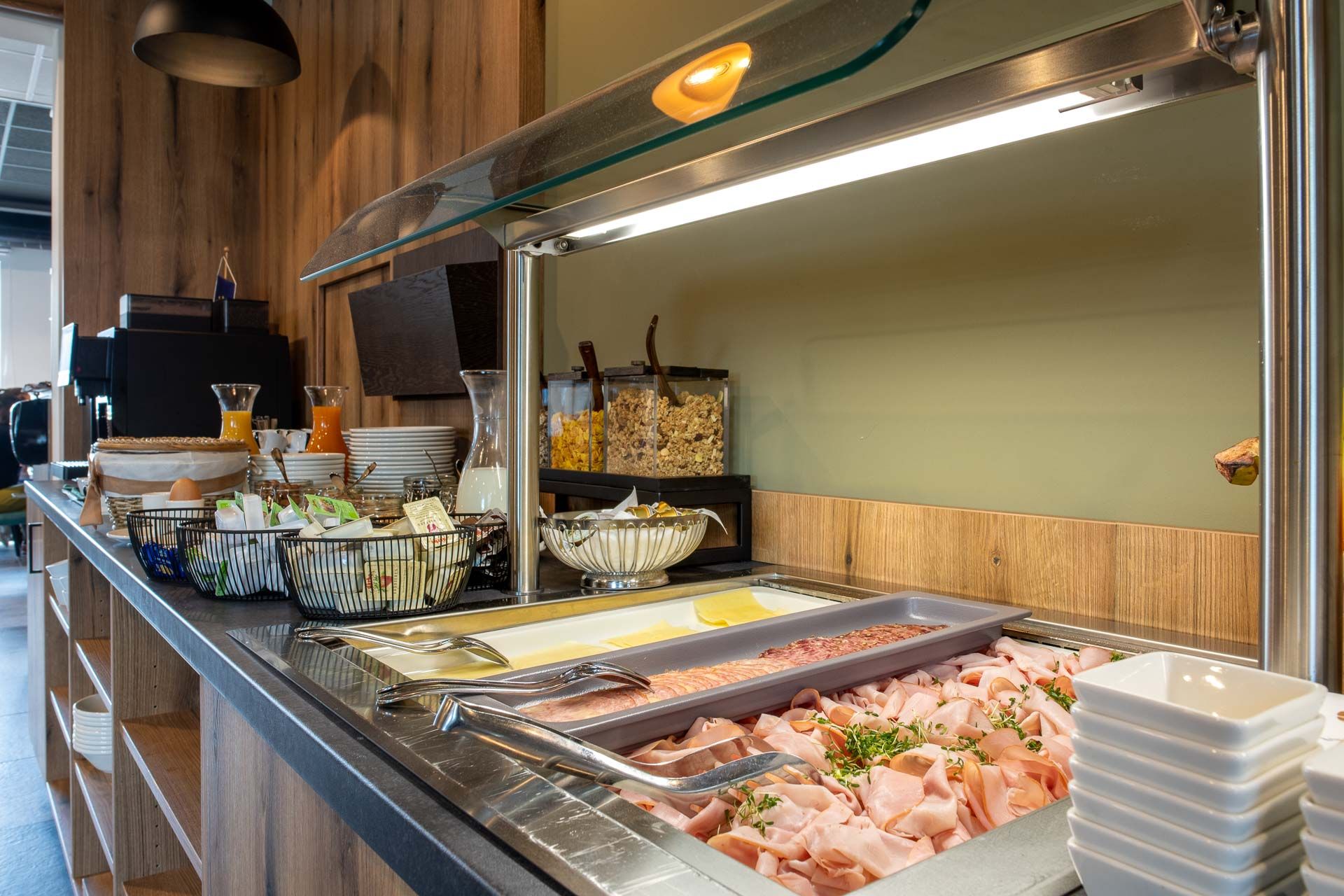 Raňajkový bufet s údeninami, syrom, müsli a nápojmi.