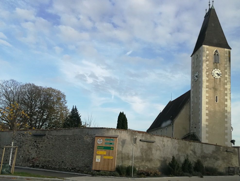 Kostol s vežou a hodinami v Hafnerbachu, obohnaný múrom.