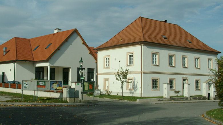 Fara vo Walpersbachu s dvoma budovami a červenou strechou.