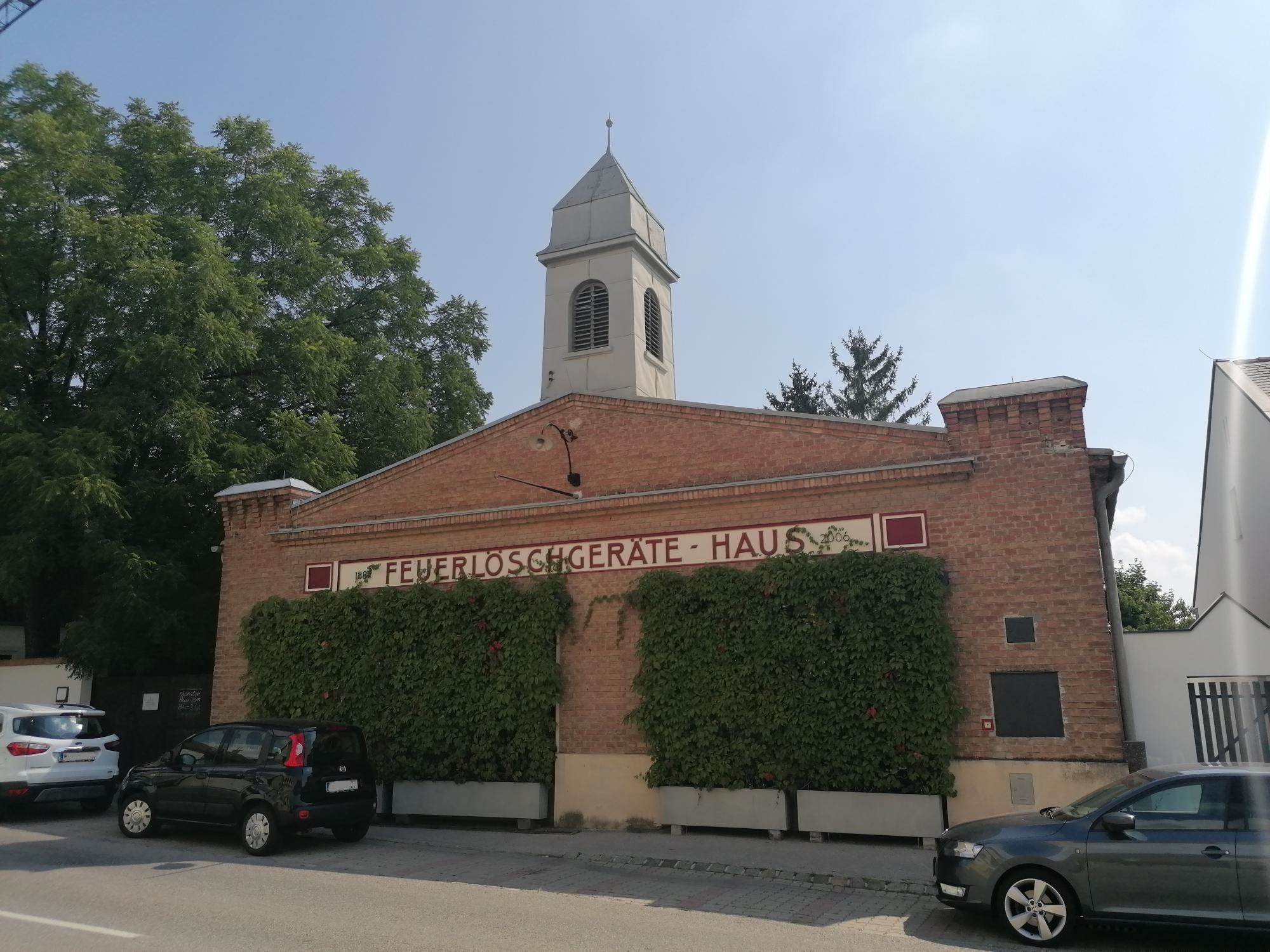 Stará hasičská stanica v Bad Fischau s tehlovou fasádou a vežou.