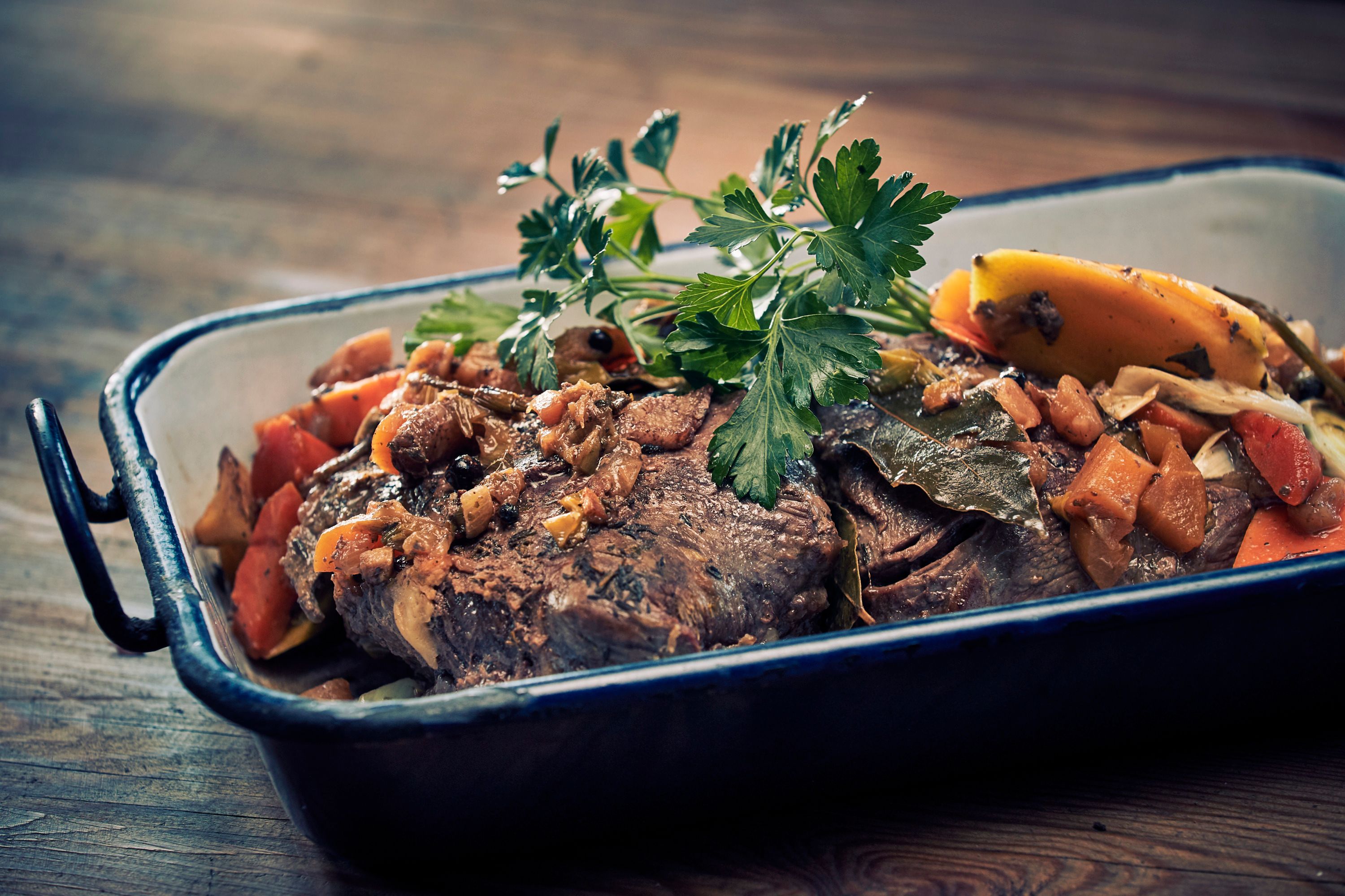 Pečené mäso so zeleninou a bylinkami v zapekacej miske.