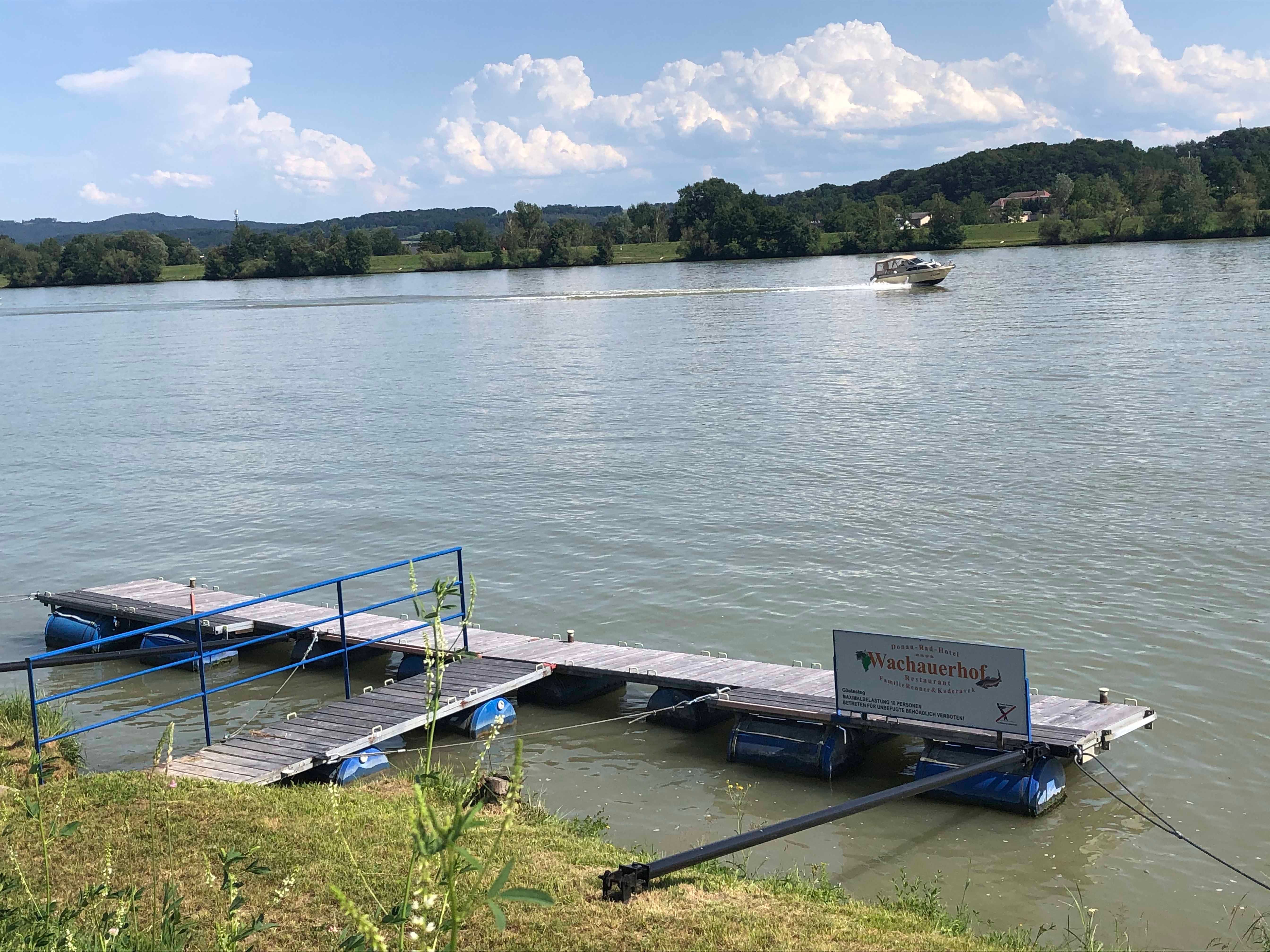 Mólo na rieke s loďou v pozadí.