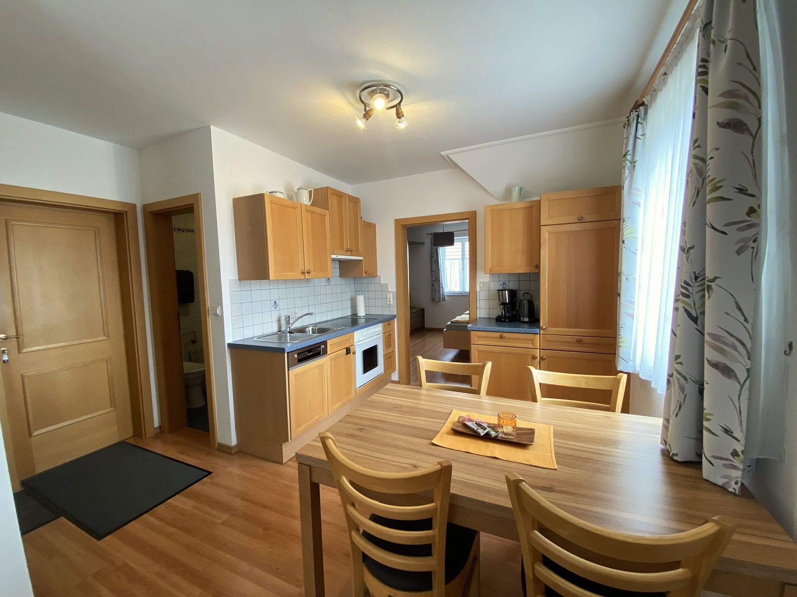 Pohľad do interiéru prázdninového bytu s kuchyňou a jedálenským stolom.