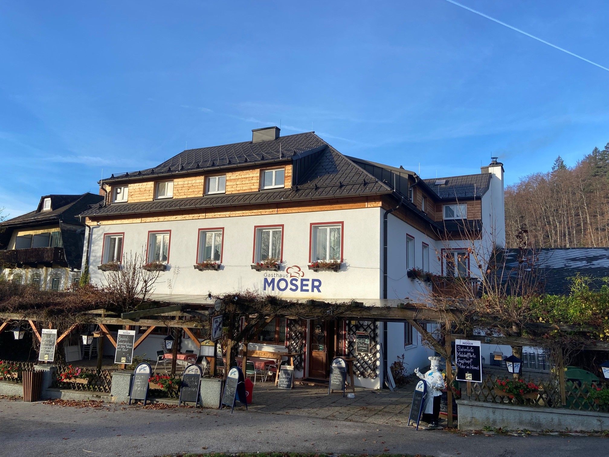 Gasthaus Moser s terasou a modrou oblohou v pozadí.