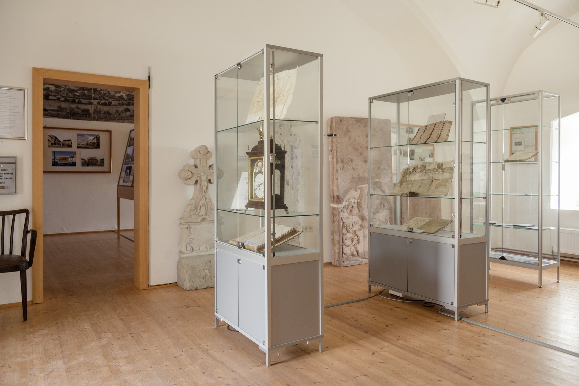 Pohľad do interiéru múzea s vitrínami s historickými dokumentmi a predmetmi.