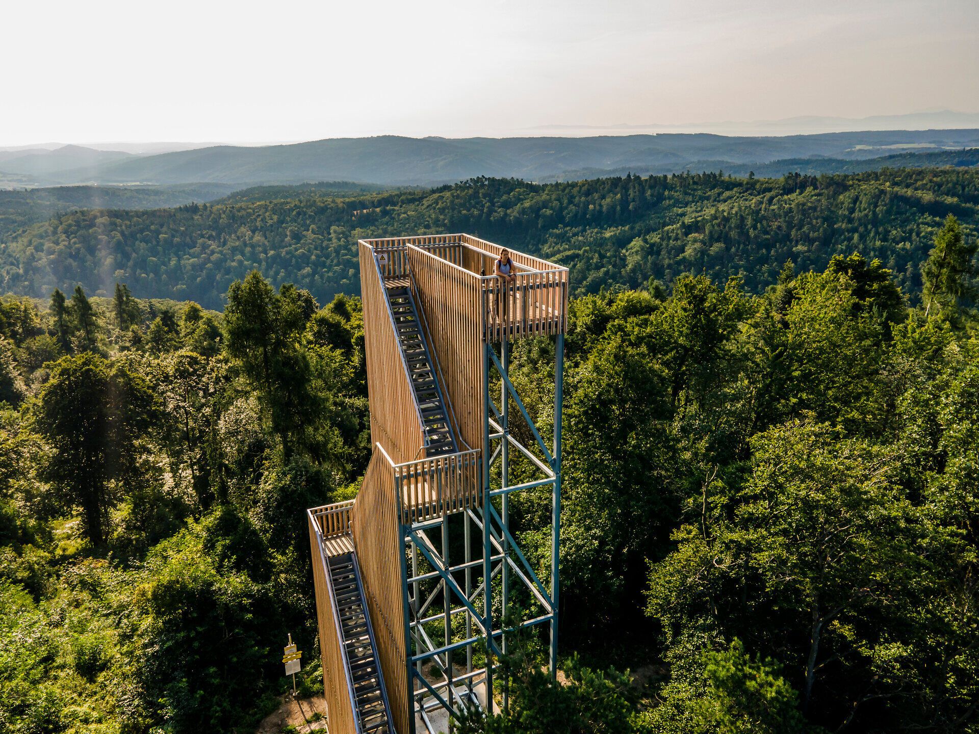 Die majestätische Aussicht von der Aussichtsplattform bietet einen atemberaubenden Blick über die sanften Hügel und dichten Wälder. Hier, wo die Natur in voller Blüte steht, spürt man die frische Bergluft und die Ruhe der Umgebung. Ein perfekter Ort, um die Schönheit des Frühlings in den Bergen zu genießen.