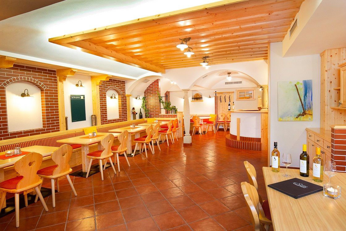 Útulná reštaurácia s dreveným nábytkom a tehlovými stenami.