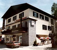 Dvojpodlažná budova s balkónom a terasou, označená "Steinbrunner".