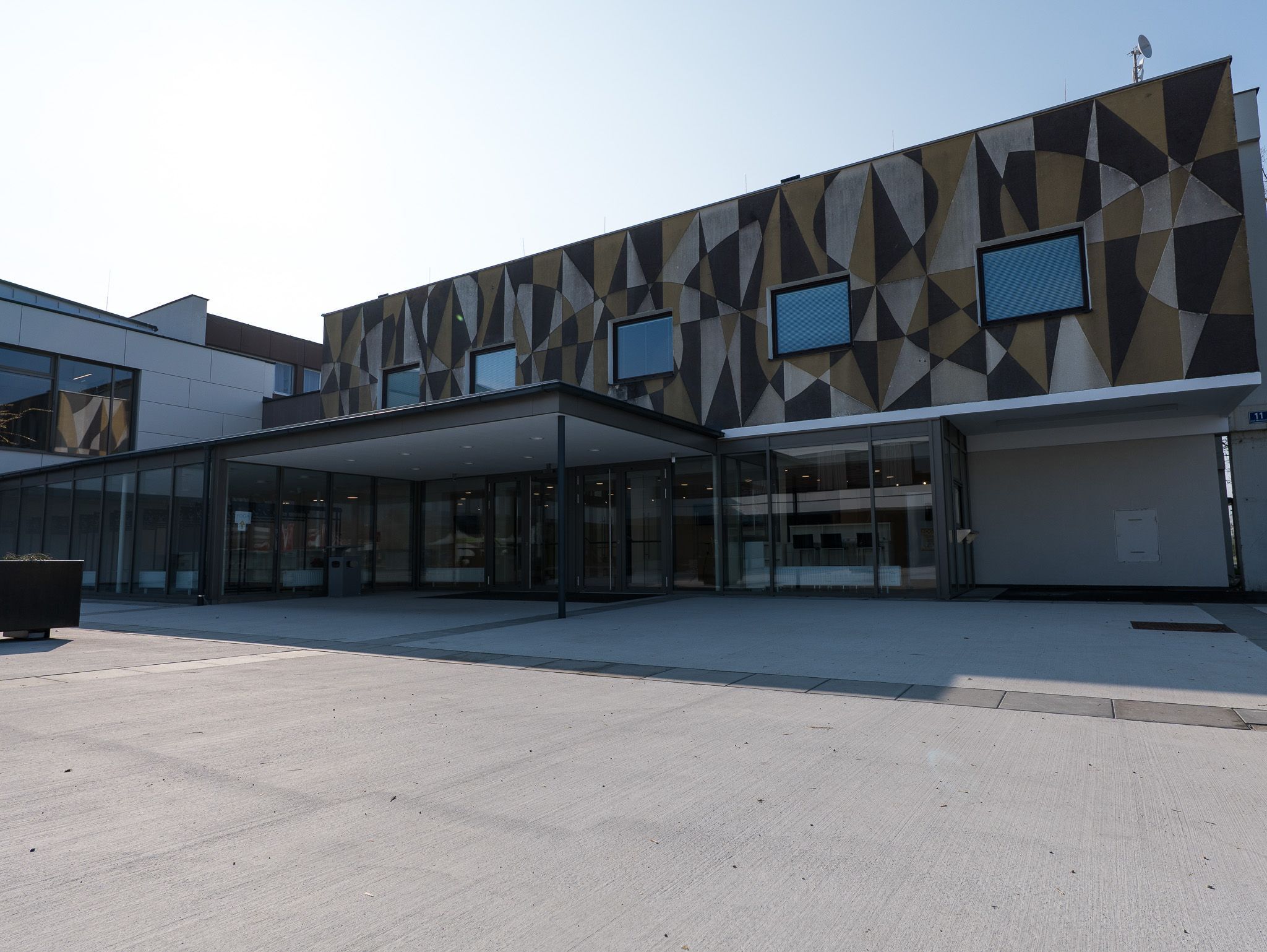 Pohľad zvonka na modernú budovu s geometrickými vzormi na fasáde.