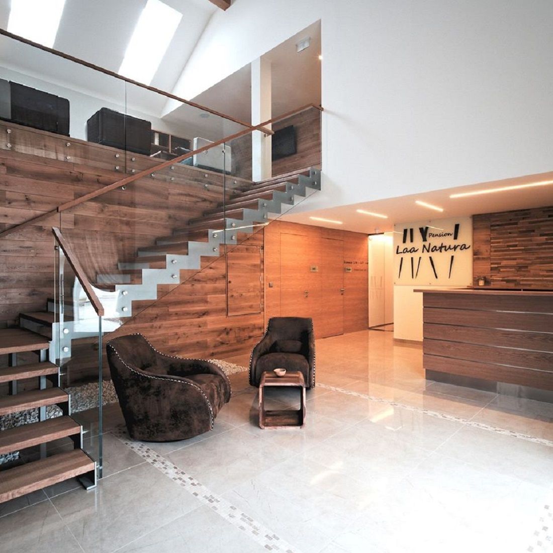Moderný vstupný priestor s dreveným obložením, schodiskom a recepciou.